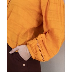 Blusa scollo a V arancio in cotone con inserti ricamo vista anteriore indossato dettaglio del ricamo sulla manica